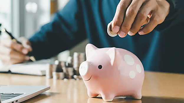 Imagen de una persona guardando el dinero en una hucha