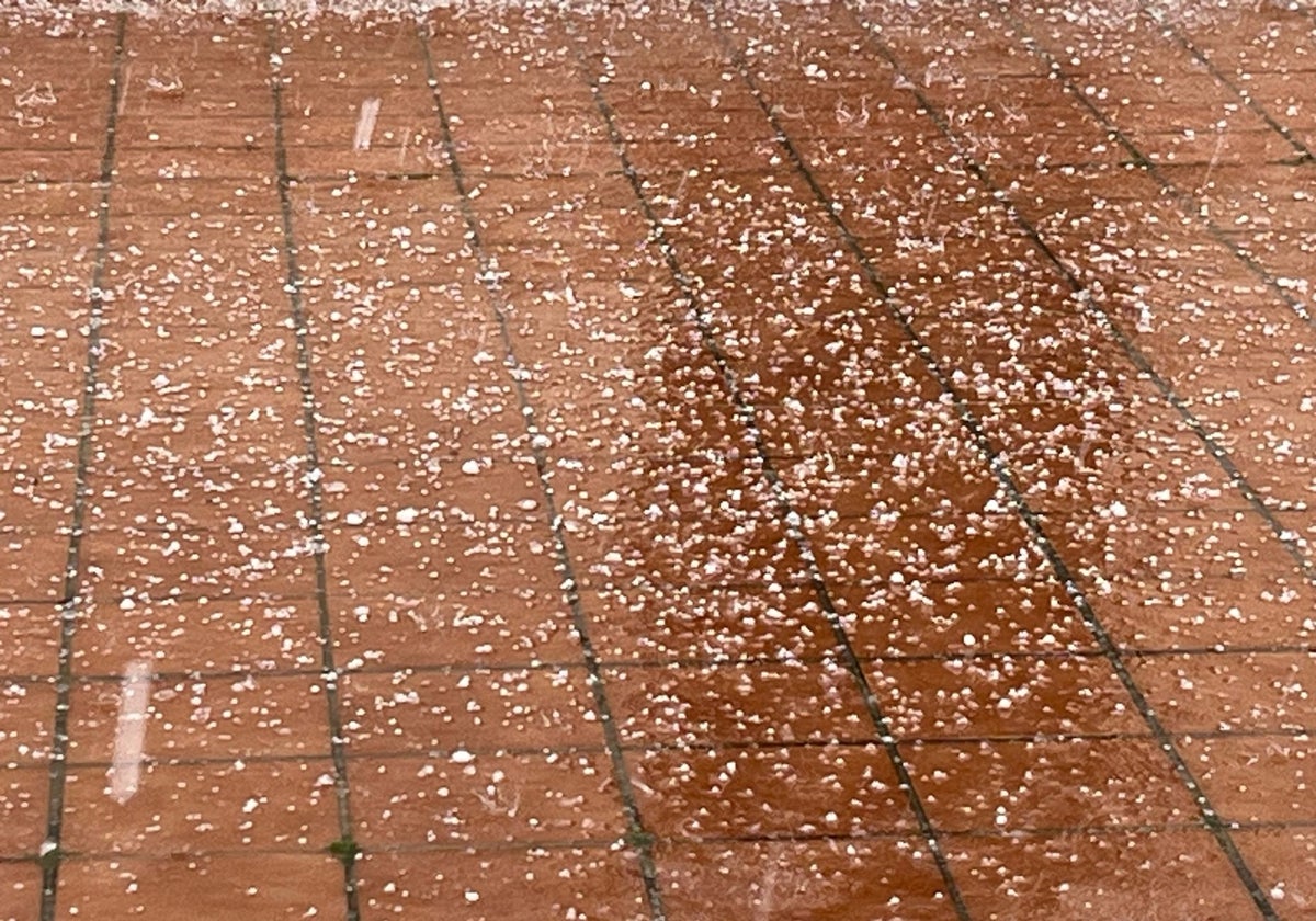 Granizos cayendo en un patio comunitario de un bloque de viviendas en Dos Hermanas