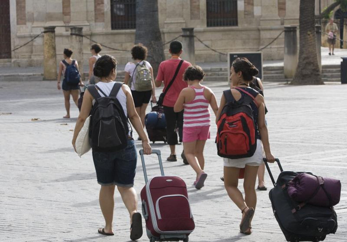 Varios turistas con maletas junto a la Catedral