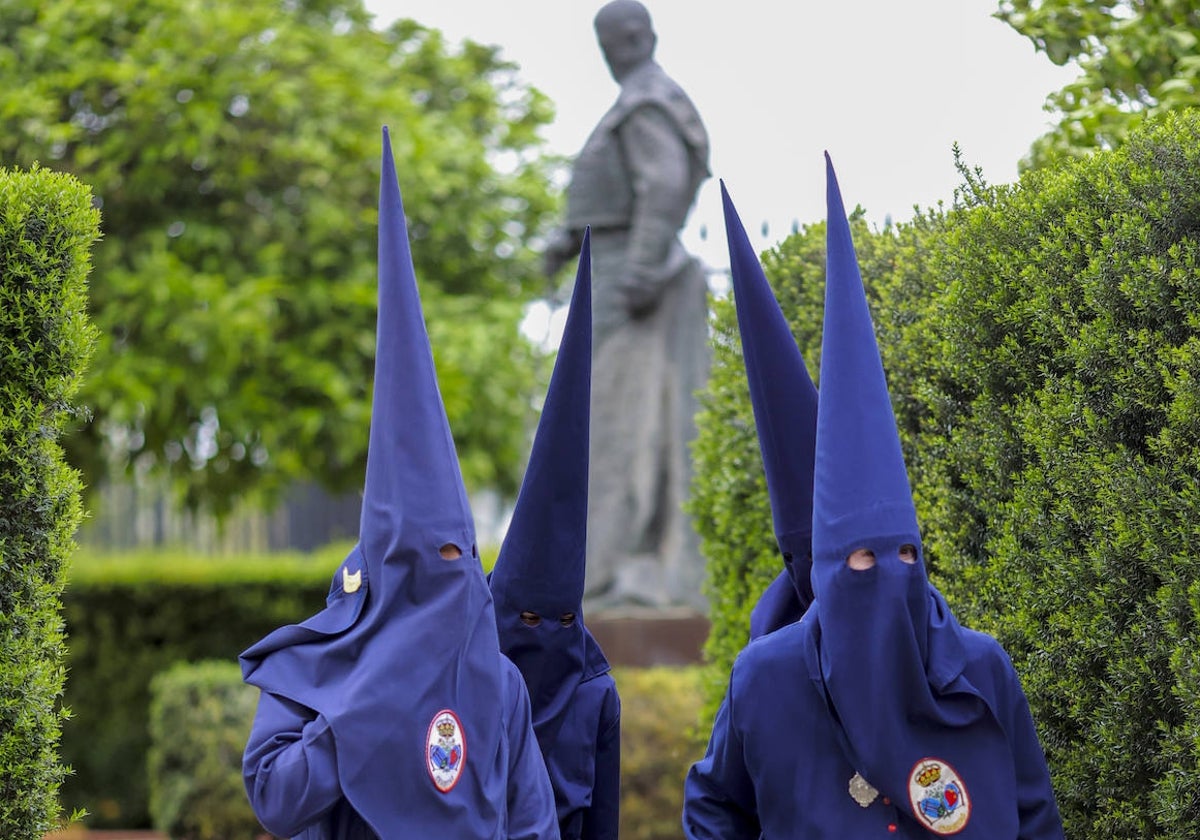 Nazarenos de El Baratillo, junto al monumento a Curro Romero