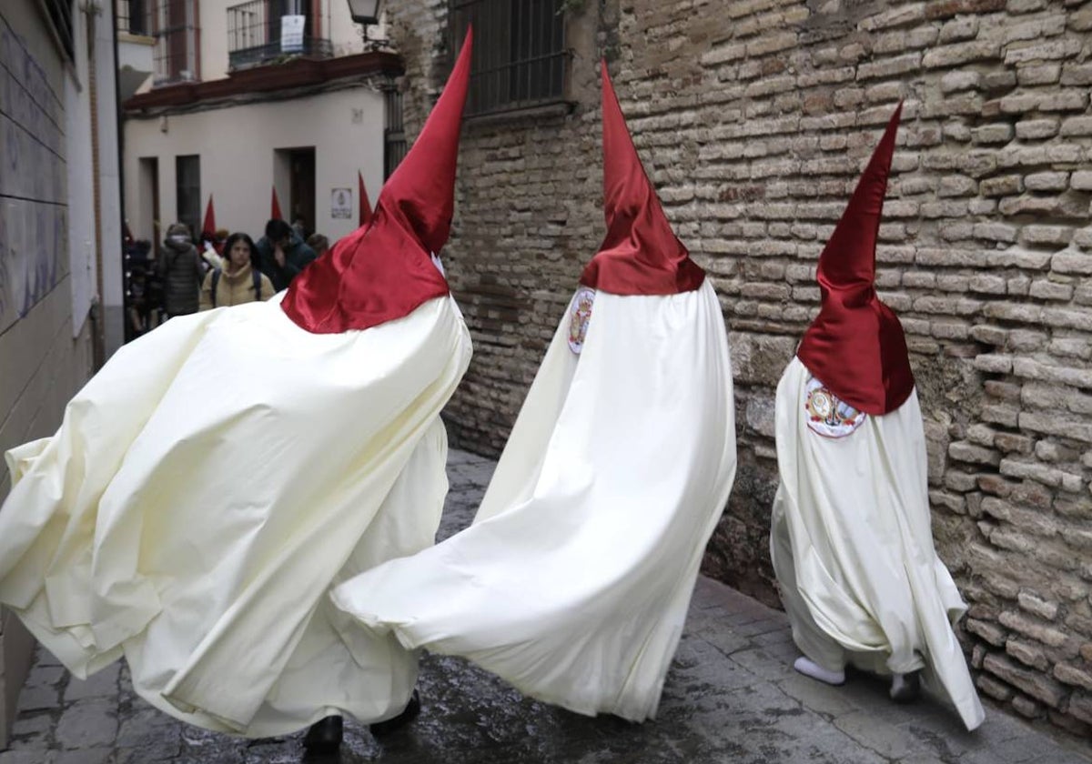 Nazarenos de la Lanzada regresando a sus hogares tras cancelarse su estación de penitencia por el tiempo