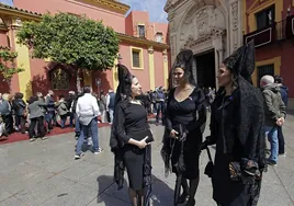 Mujeres vestidas de mantilla, esperan en la plaza de San Lorenzo para visitar las imágenes del Gran Poder y la Virgen del Mayor Dolor y Traspaso