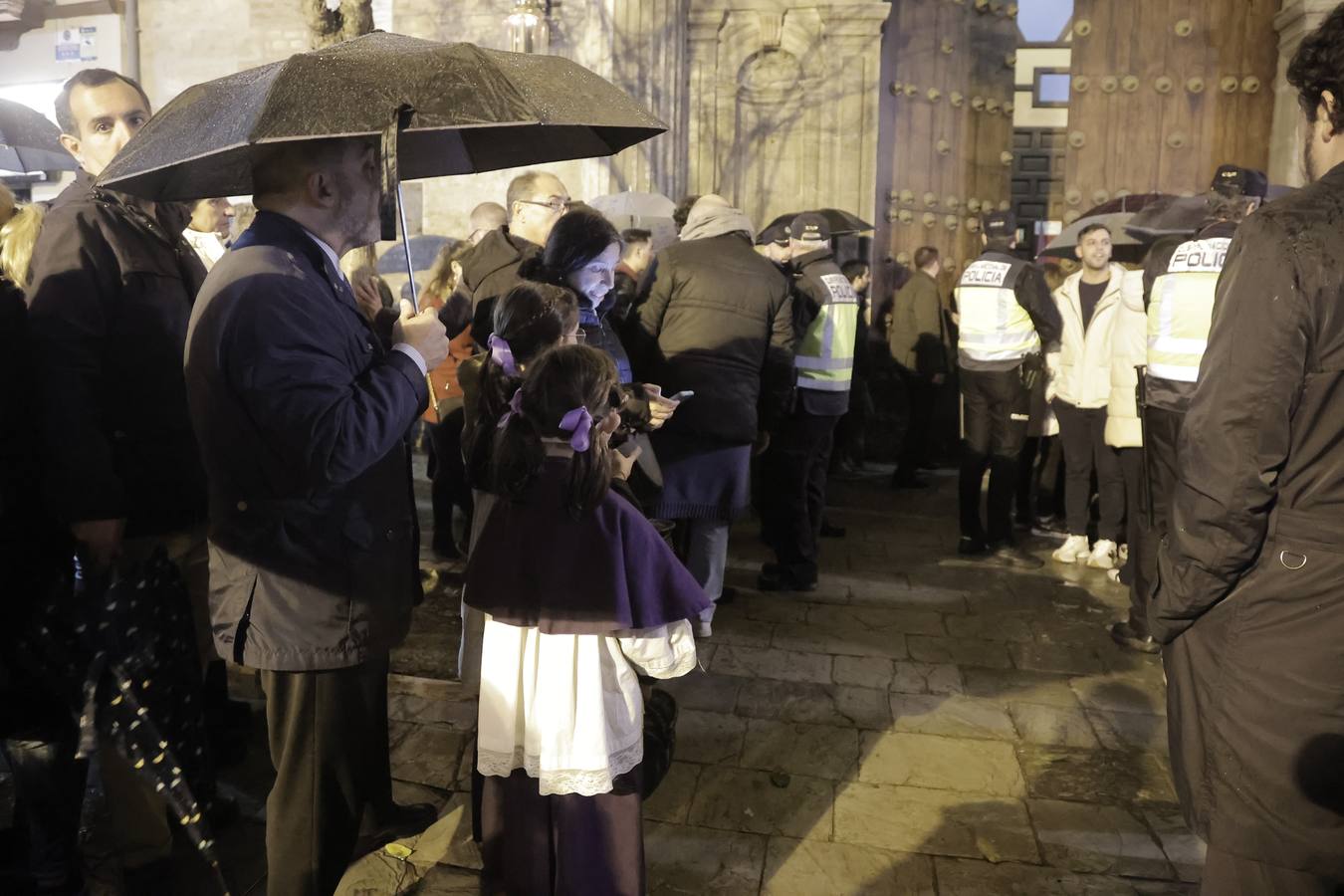 Nazarenos y costaleros se lamentan a las puertas de la iglesia de la Anunciación tras la decisión de no salir de la hermandad del Valle