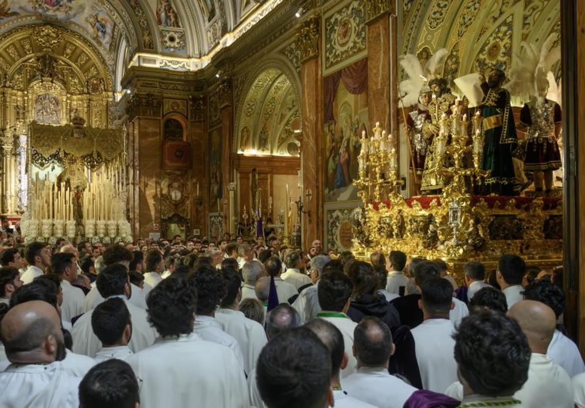 Nazarenos de la Macarena encomendándose a sus titulares en esta aciaga Madrugada