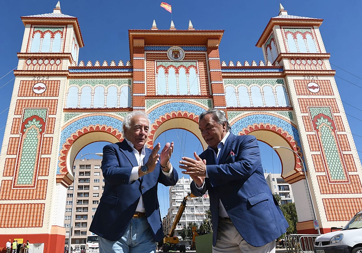 El dúo musical delante de la portada de la Feria