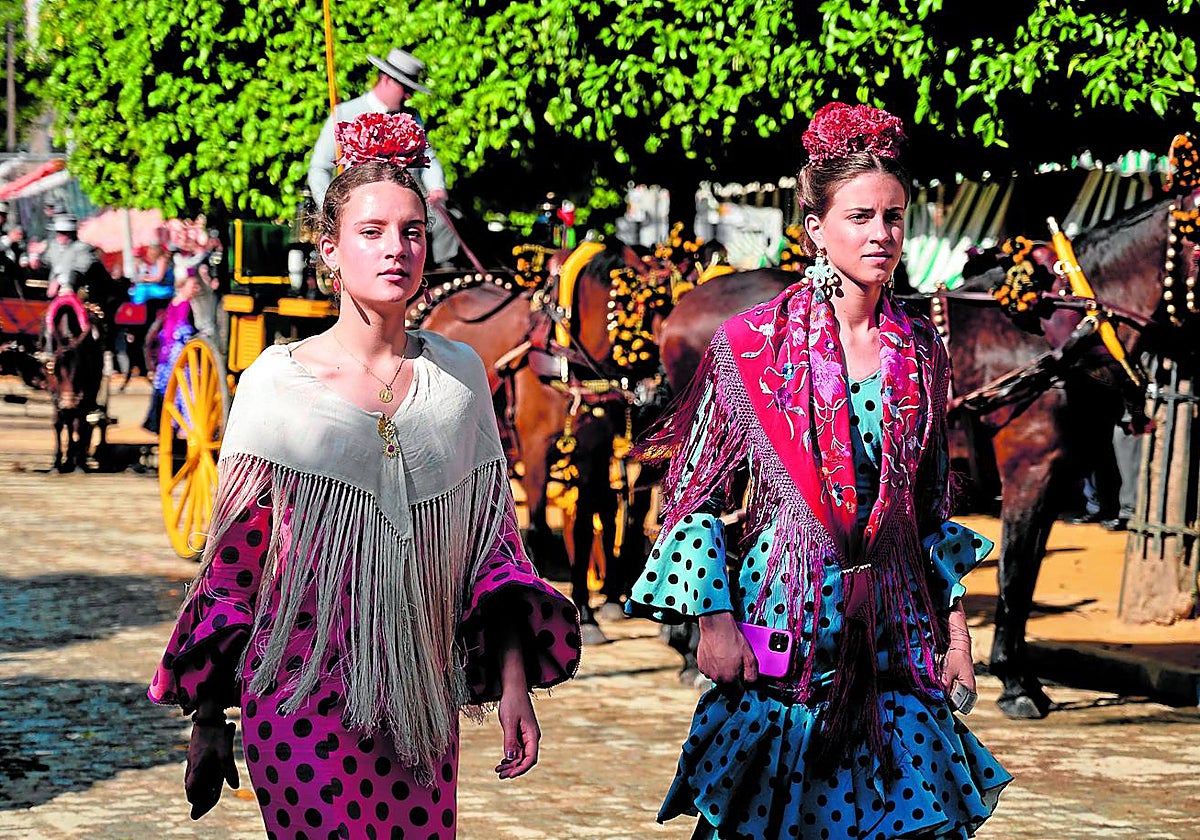 Dos jóvenes flamencas luciendo traje de gitana en el real