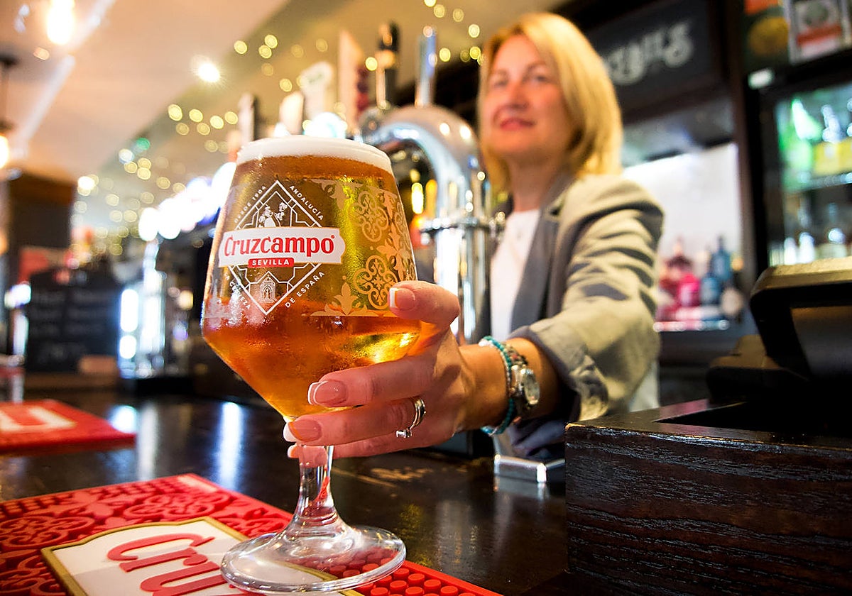 Una mujer sirve una cerveza Cruzcampo en Reino Unido