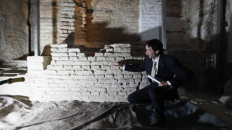 El arqueólogo José Antonio Valiente señala los huecos de las hornacinas situadas en el antiguo muro del hejal de la sinagoga