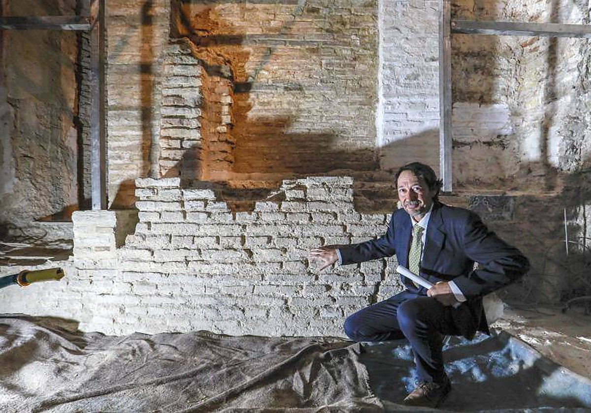 El arqueólogo José Antonio Valiente señala el muro del hejal que ha salido a la luz en la iglesia