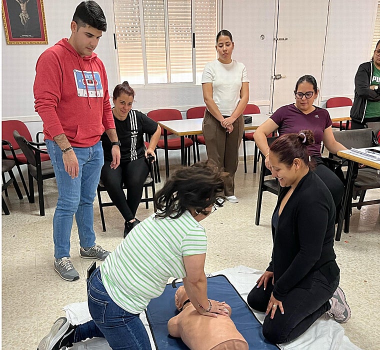 El enfermero Diego José Géniz supervisa un masaje de reanimación a una cuidadora de Los Pajaritos en la parroquia de La Blanca Paloma