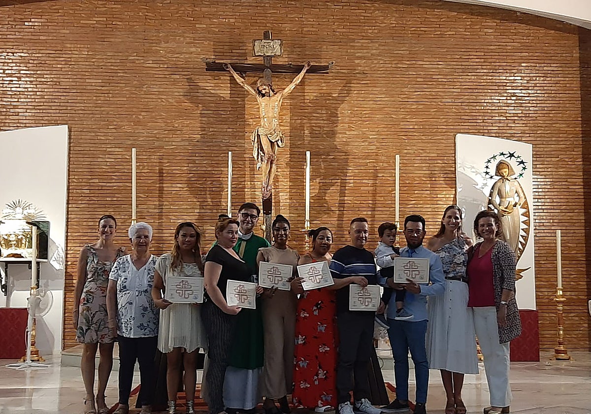 María Paz Borrego Esteban, enfermera del Centro de Salud de Amate (primera por la izquierda), junto a la primera promoción de cuidadoras de Los Pajaritos con sus diplomas en la parroquia de la Blanca Paloma. A la derecha, Carmen Flores Navarro Pérez y Alicia Botello Hermosa, ambas profesoras de la Universidad de Sevilla