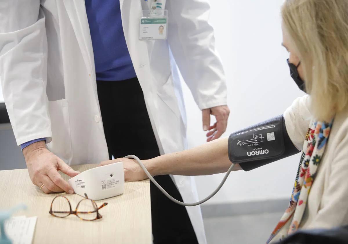 Un facultativo toma la tensión de una paciente en un centro de salud