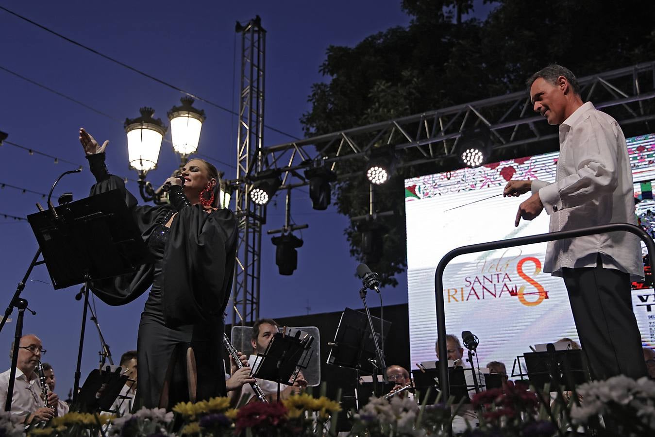 La calle Betis ya está encendida para celebrar su Velá tras el pregón de José Yélamo y la actuación de Silvia Pantoja y Arcángel
