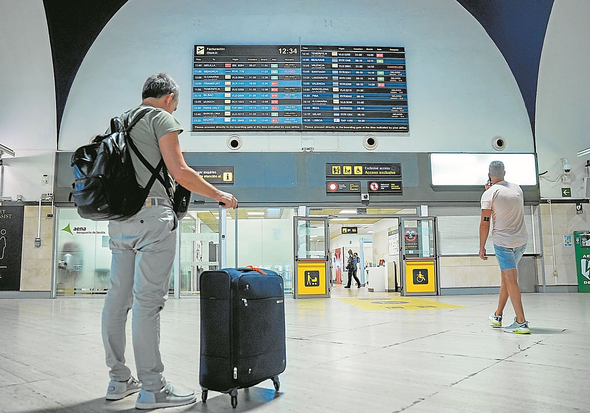Un viajero junto a su maleta en el aeropuerto de San Pablo