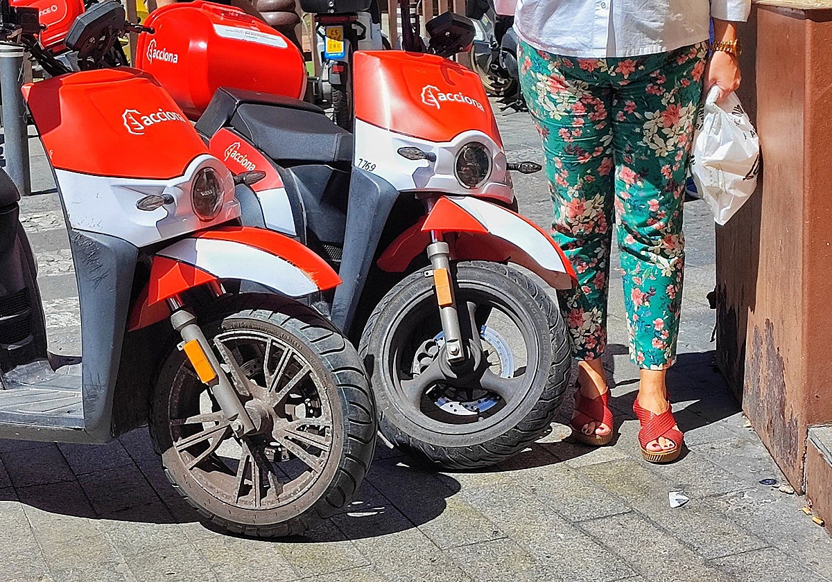 Una mujer trata de pasar por la acera en una calle sevillana