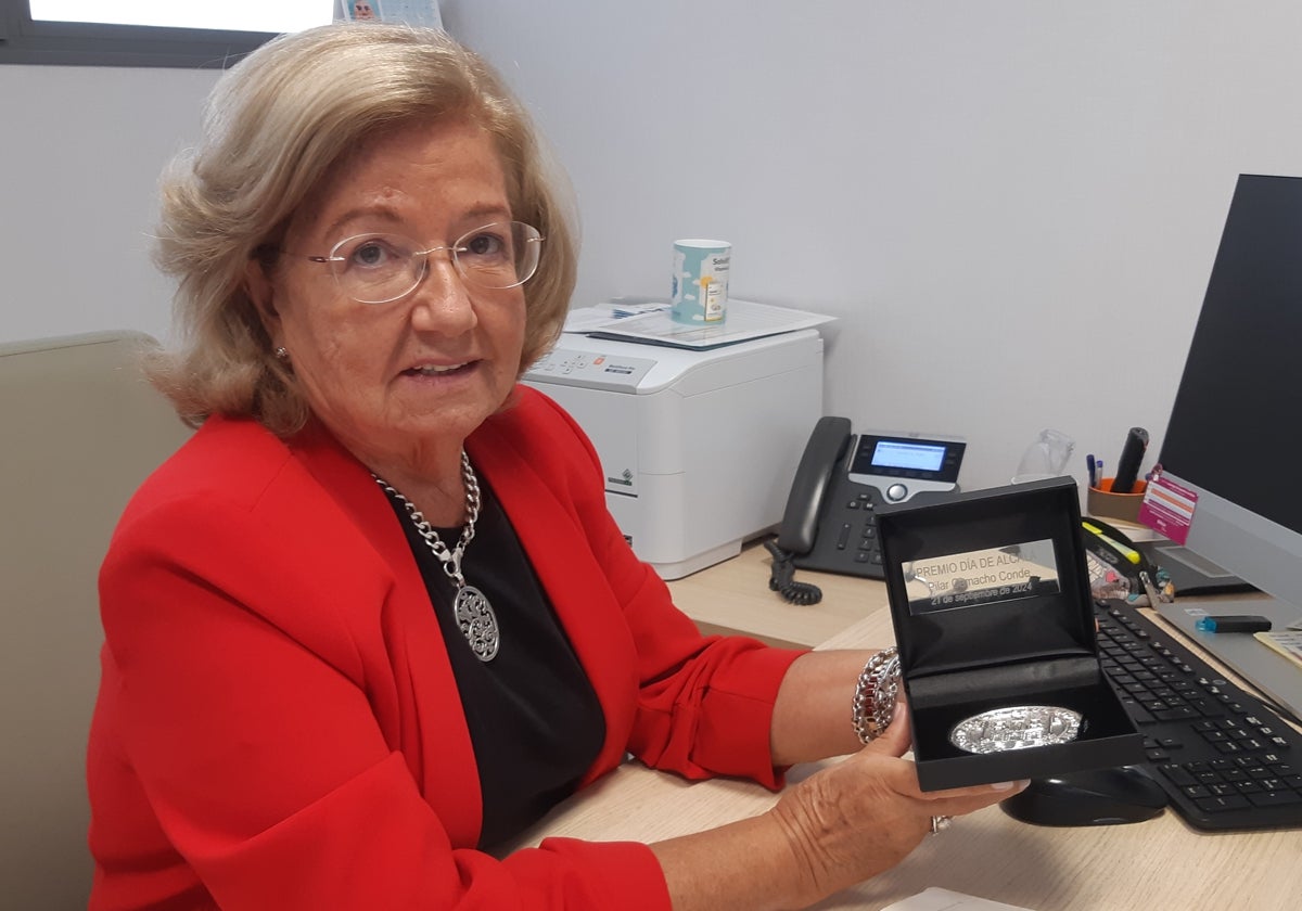 Pilar Camacho Conde muestra la medalla que le ha acaba de conceder el Ayuntamiento de Alcalá de Guadaira por su labor asistencial