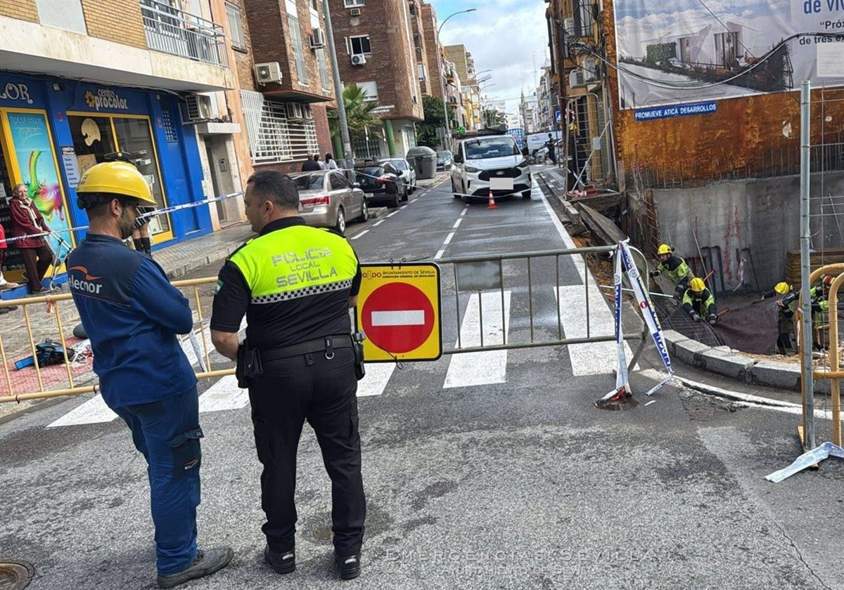 Un agente junto a un operario en la confluencia de ambas calles