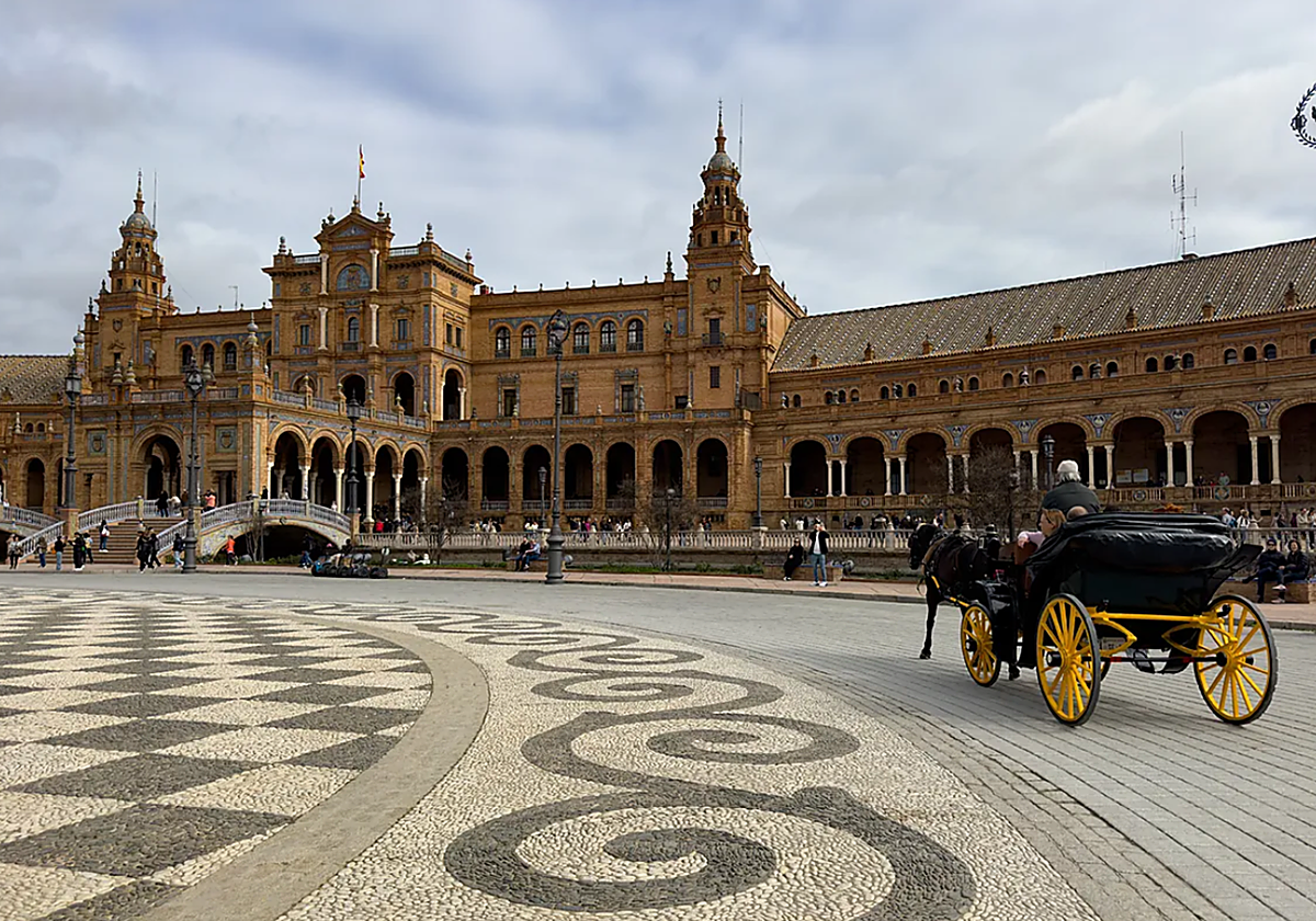 Varios visitantes acuden a la Plaza de España durante una jornada de nubes en Sevilla