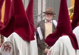 Una banda con nazarenos recorre Sevilla en el mes de noviembre