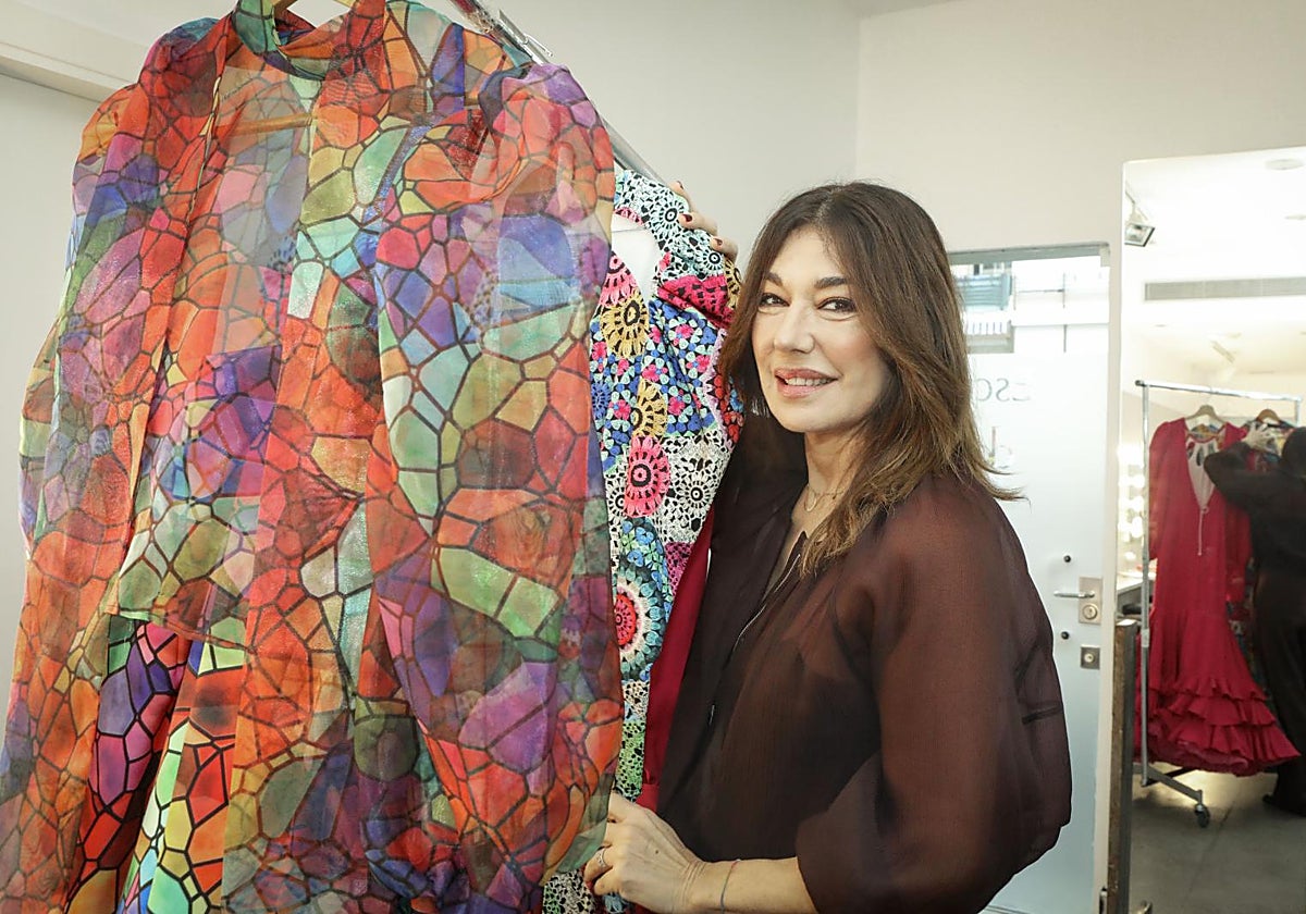 Raquel Revuelta rodeada de trajes de flamenca