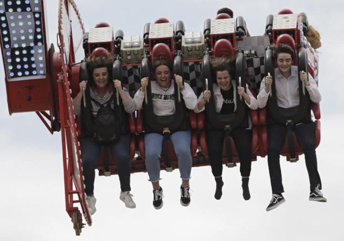 Jóvenes en una atracción de la Calle del Infierno en la Feria de Abril