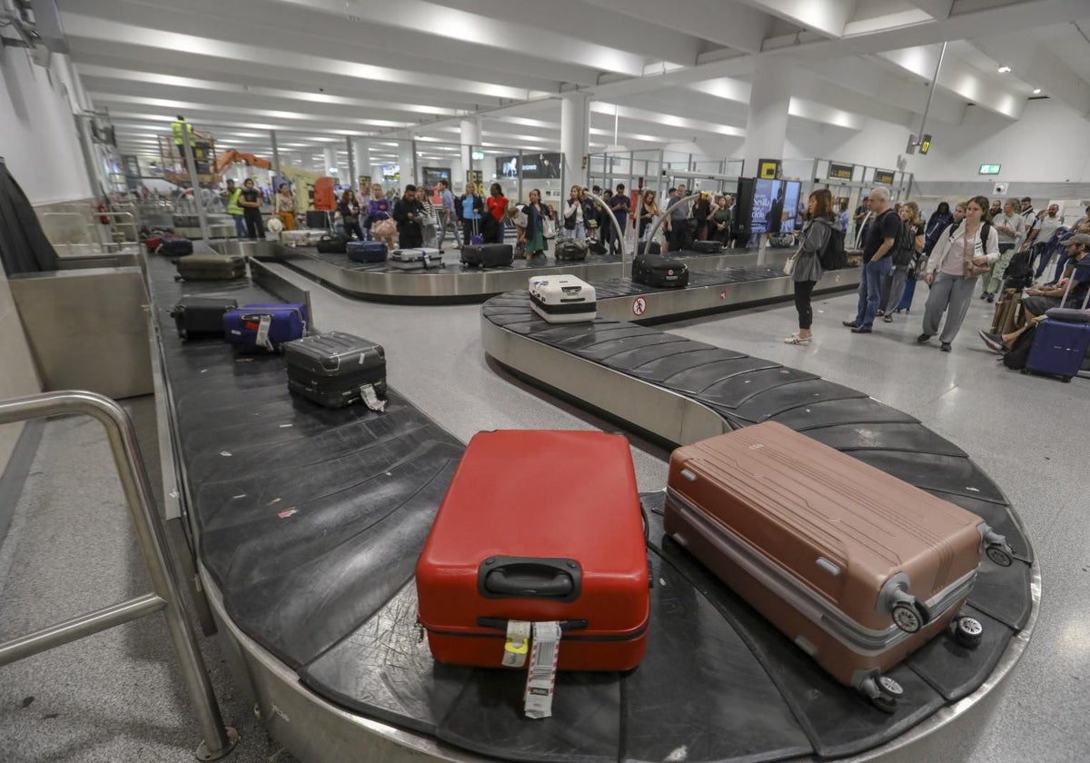 Pasajeros esperan a su equipaje en la terminal de llegadas del aeropuerto de Sevilla