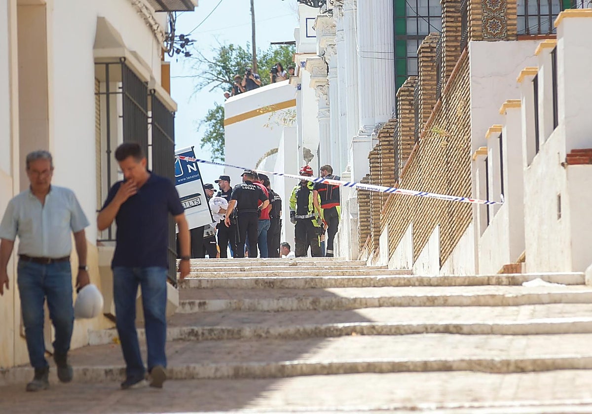 Efectivos de Bomberos y Policía Local, junto al coche de los servicios del tanatorio en la calle Santa María