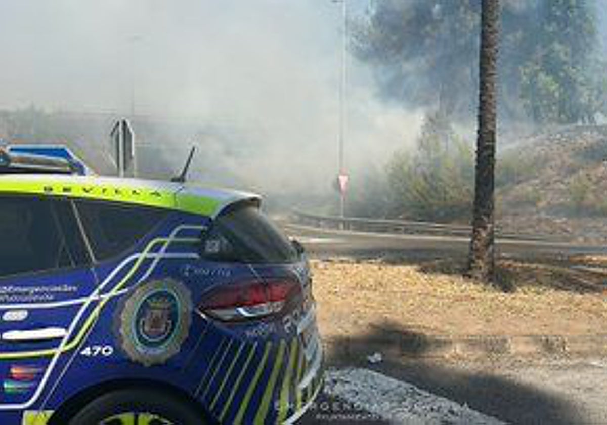 Un coche de la Policía Local junto al lugar del incendio en la SE-30