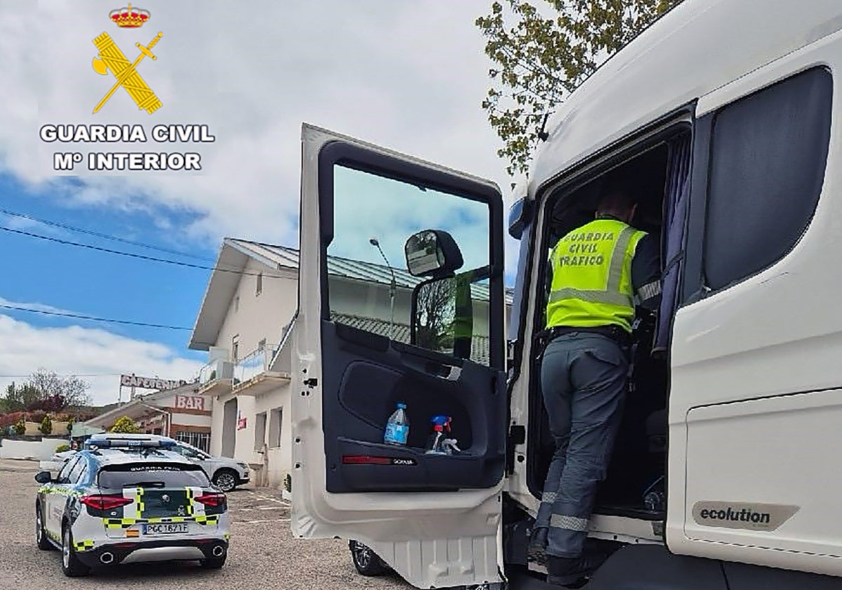 Un agente de la Guardia Civil de tráfico inspecciona el camión