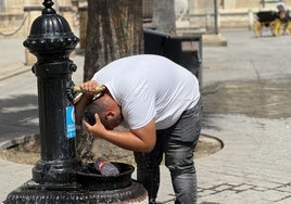 Un hombre se refresca en una fuente de Sevilla este martes