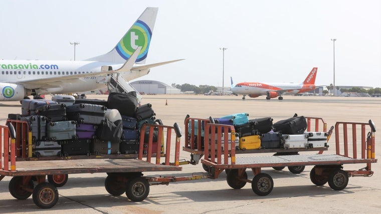Pilas de maletas en los remolques del aeropuerto de Sevilla un día cualquiera