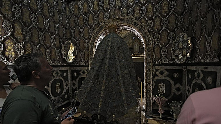 Un macareno admira los dos perfiles de la Virgen de la Esperanza antes de la última partida de la dolorosa
