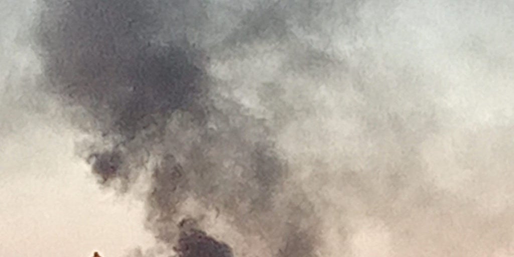 Arde un coche junto a un colegio del Polígono Sur de Sevilla levantando una gran columna de humo