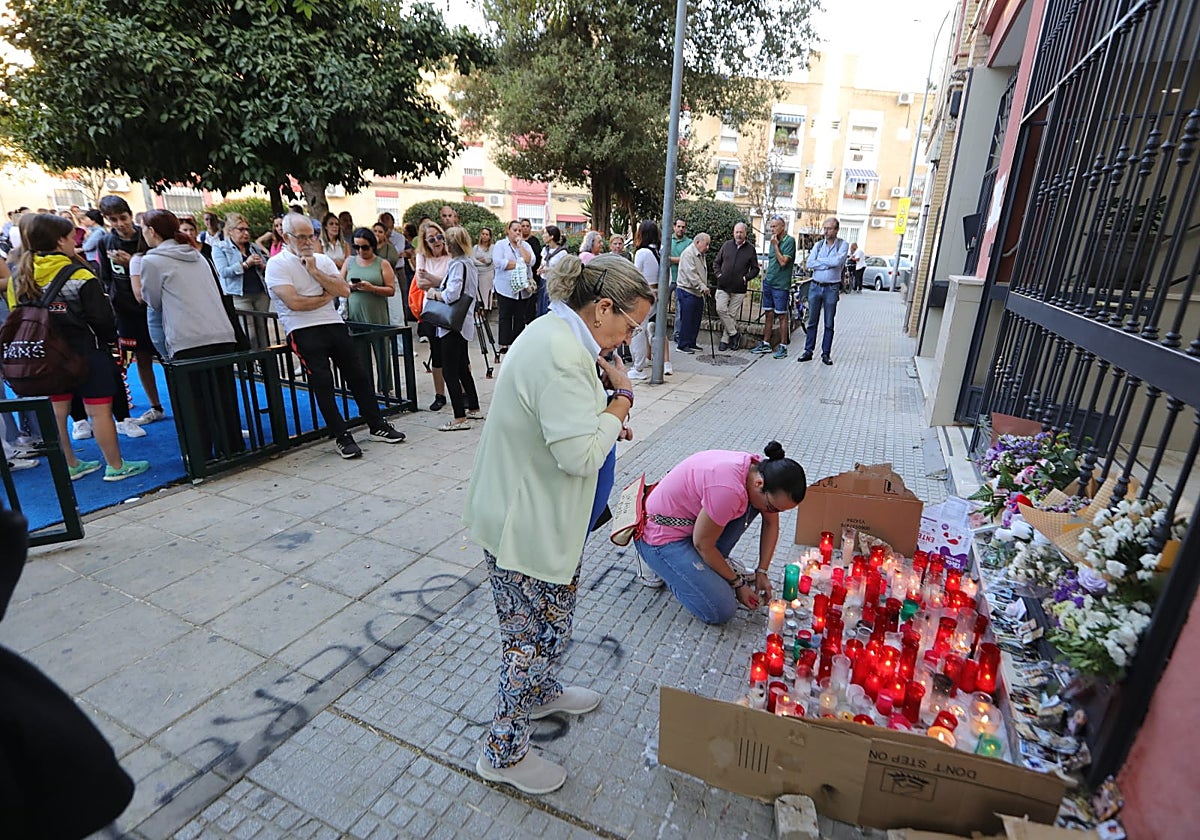 Unas vecinas colocan velas en el portal del edificio donde vive la familia de Sandra