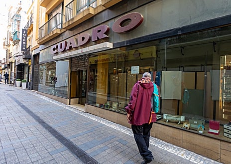 Imagen secundaria 1 - Arriba, un hombre observa la vitrina de la tienda de disfraces Pichardo, en la plaza Fernando de Herrera; abajo, a la izquierda, la cristalera de Cuadro en Alcaicería de la Loza, vía en la que también ha echado el cierre la tienda de complementos de Antonio Hierro, a la derecha 