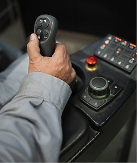 Imagen secundaria 2 - Arriba, un trabajador maneja las máquinas que se encuentran a cientos de kilómetros bajo tierra. Abajo a la izquierda, vista de las instalaciones de Sandfire Matsa y a la derecha, detalle del mando con el que se mueve la maquinaria pesada.