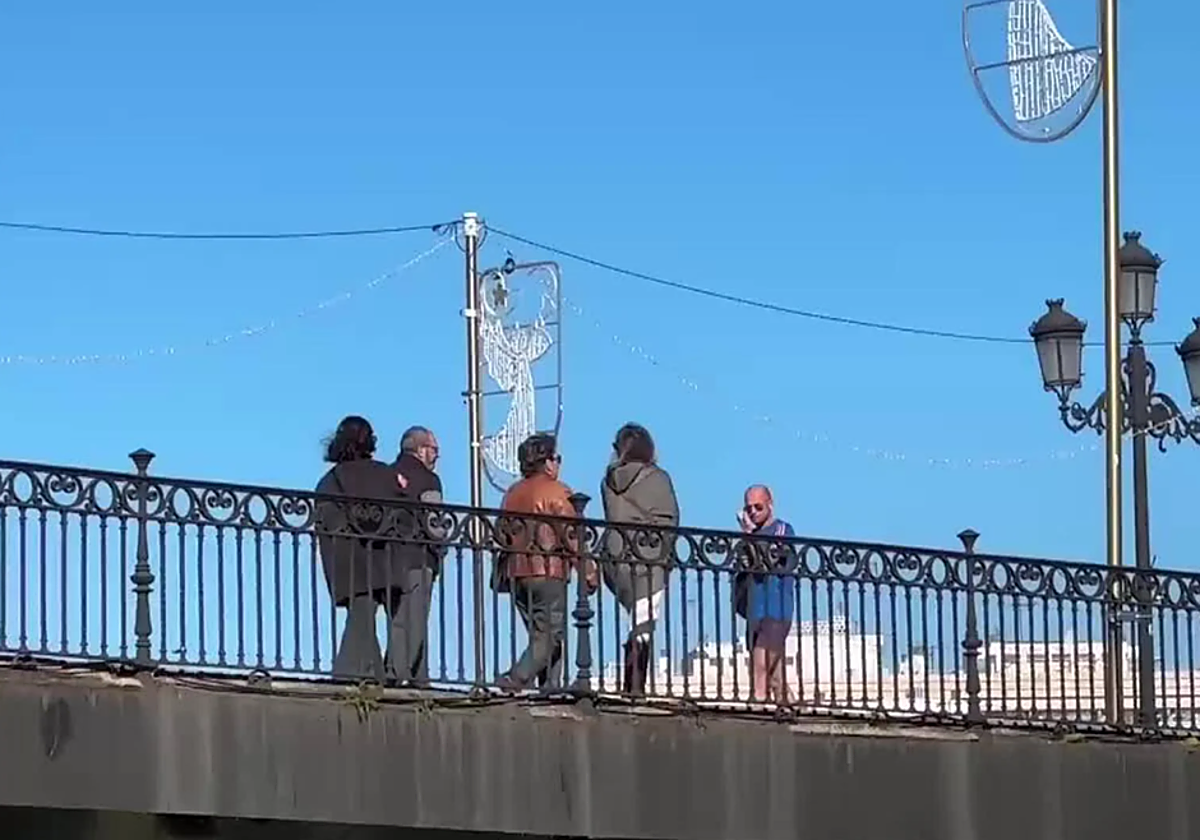 Gente cruzando el Puente de Triana durante un día de frío en Sevilla
