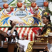 Un coche de caballos parado delante de una de las casetas de la Feria de Sevilla