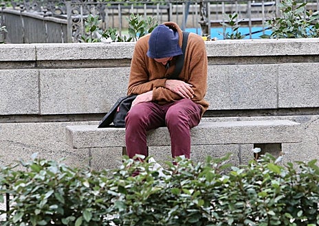 Imagem Secundária 1. Acima: Mulher sentada no chão coberta por um cobertor; Abaixo, na praça, está sentado um homem com a cabeça baixa e à direita está outra mulher implorando. 
