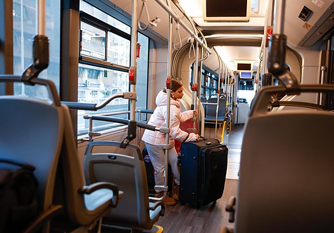 Una joven lleva una maleta en un autobús en el aeropuerto de Sevilla.