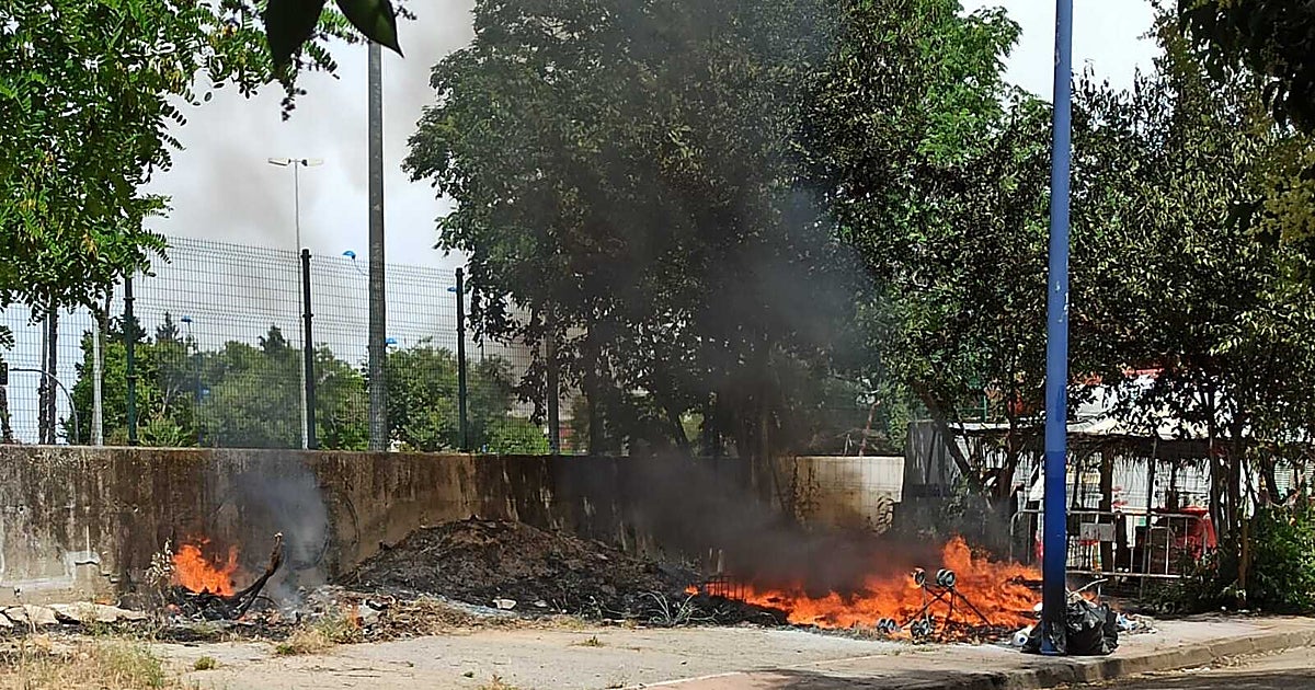 Un incendio de rastrojos y basura junto al aparcamiento de Isla Mágica provoca una gran columna de humo