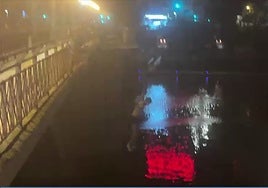 Unos jóvenes se tiran al río desde el puente de San Telmo la primera noche de la Velá de Santa Ana