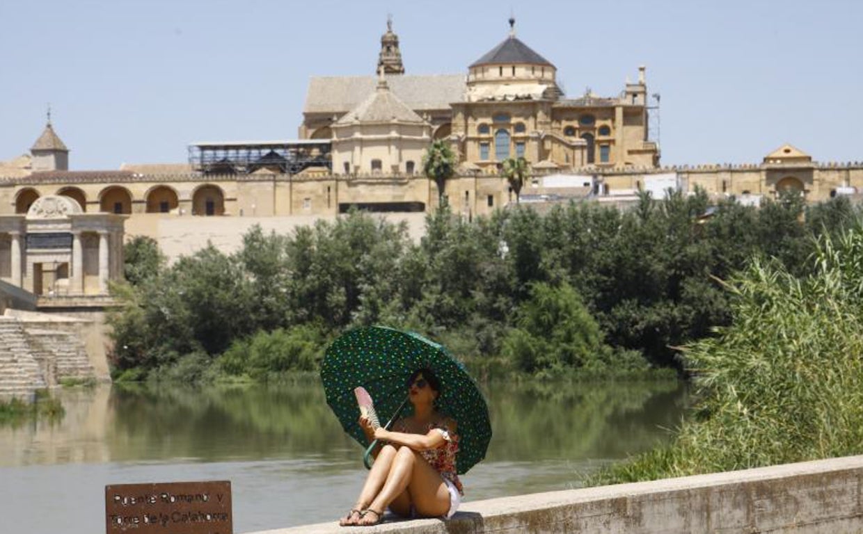 Una turista en Córdoba protegiéndose del calor con un paraguas