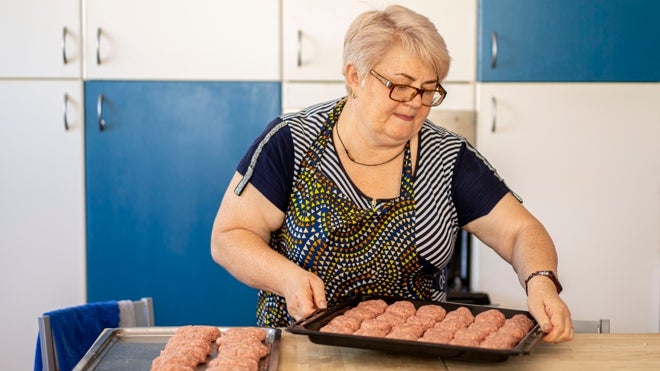 Una de las cocineras prepara la comida para los niños