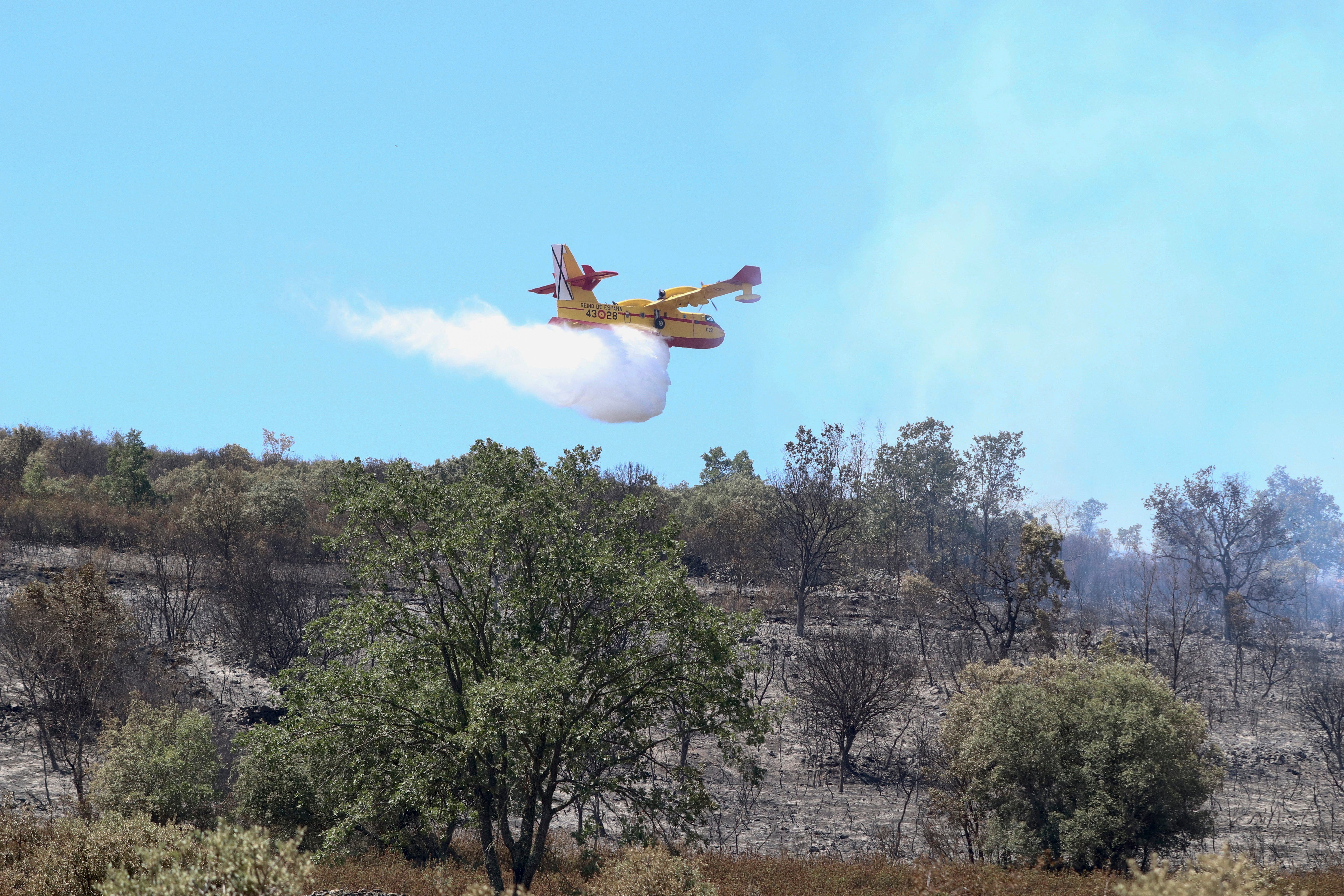 Un hidroavión suelta agua en uno de los focos todavía activos del incendio en la comarca de Tábara, en Perilla de Castro (Zamora)