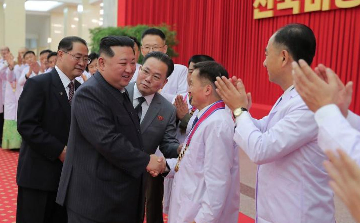 Kim Jong-un saluda a un funcionario de salud en el acto de celebración por la victoria contra el Covid
