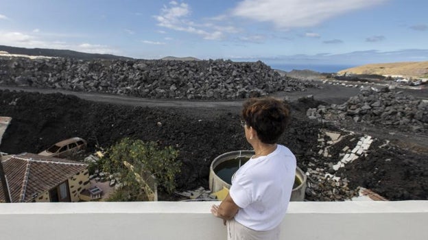 Rosabel Díaz Brito mira el muro de lava que tiene frente a su casa