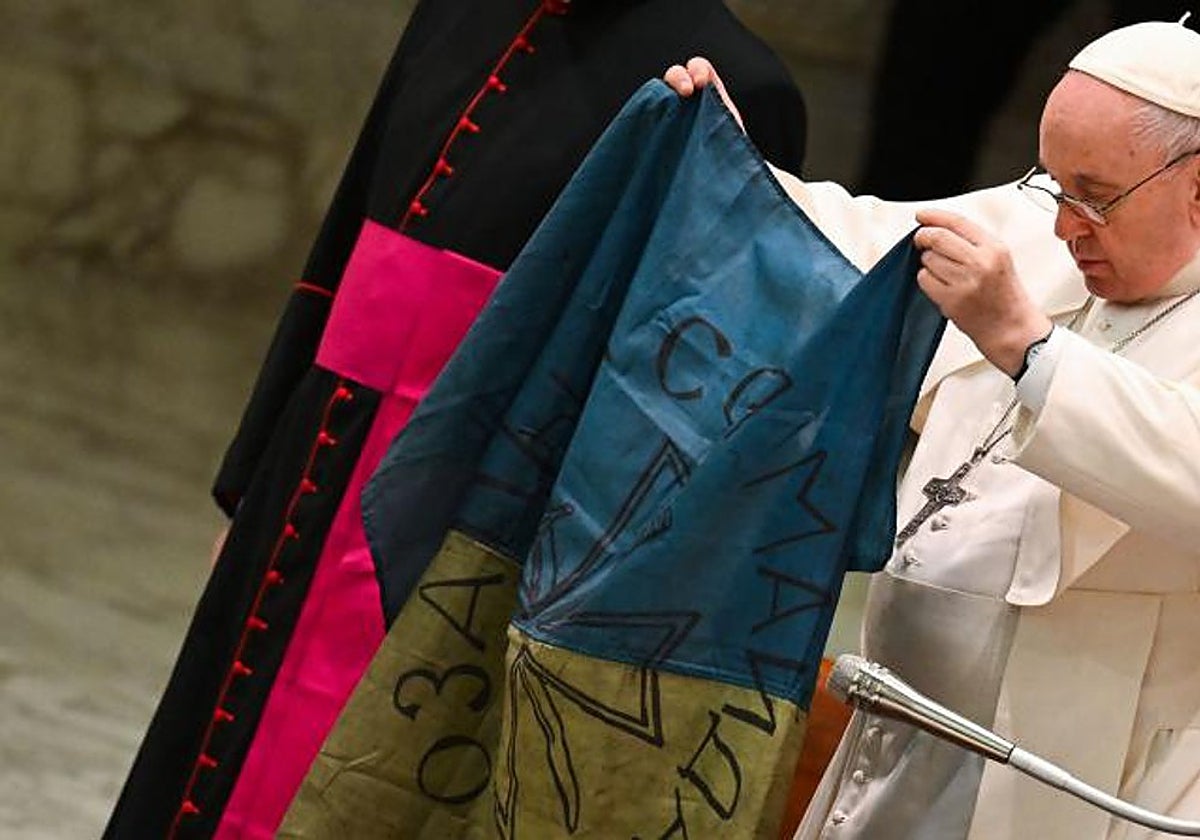 El Papa muestra la bandera ucraniana que recibió de la ciudad de Bucha en una audiencia pública el pasado abril