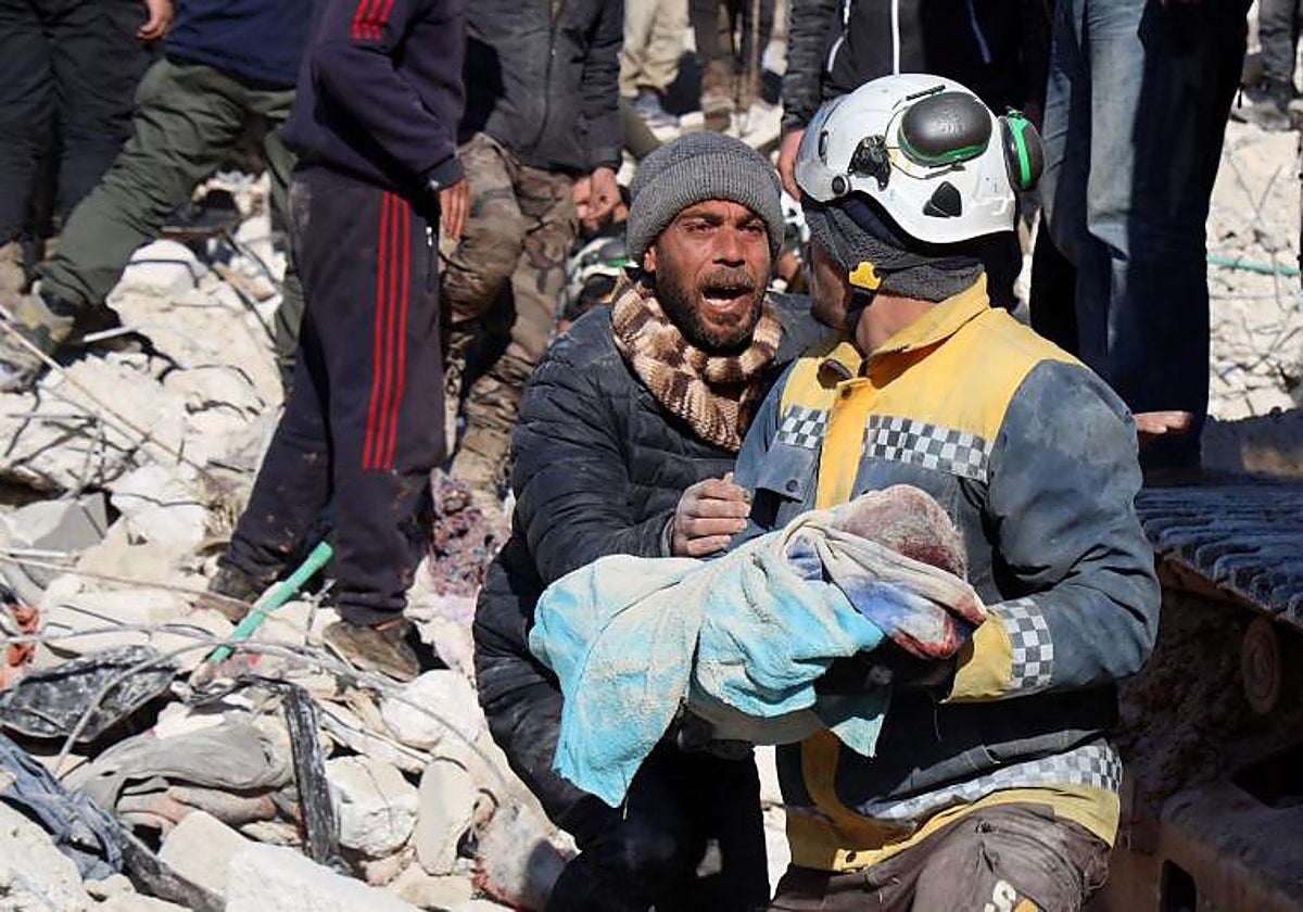 Un hombre llora al ver que el cuerpo de su bebé es rescatado de entre los escombros, en la ciudad de Harim, Siria