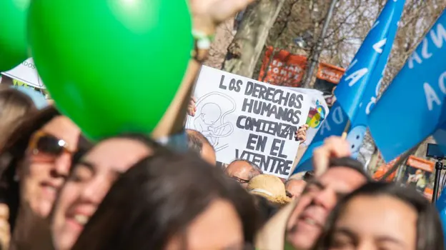 Varios manifestantes portan globos verdes, el color oficial y carteles en defensa de la vida
